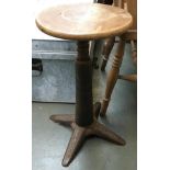 A Singer sewing machine stool, circular wooden seat on heavy adjustable cast iron base, 'SINGER'
