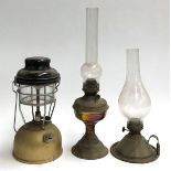 Two oil lamps, one with loop carry handle, both with glass chimneys, the taller 49cmH; together with