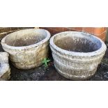 A pair of large composite stone planters, in the form of barrels with ivy leaf decoration, each