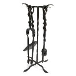A set of wrought iron fire tools on stand, to include poker, tongs, brush and shovel