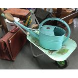 A Haws blue enamel watering can with brass rose; together with a child's wheelbarrow