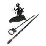 A cast iron figural doorstop, wrought iron fire poker, and walking cane with lion mask pommel