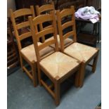 A set of four contemporary oak ladderback chairs, with drop-in rush seats