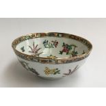 A Chinese bowl depicting various flowers and fruits, the rim heightened in gilt, 18cmW