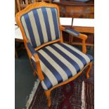A modern oak continental style open armchair, with striped upholstered seat on cabriole legs
