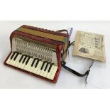 A Hohner Mignon II 12 button piano accordion; together with a small quantity of sheet music