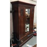 A 20th century mahogany hanging wardrobe, single hanging door with bevelled mirror, above single