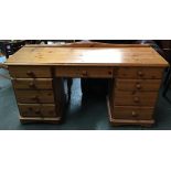 A narrow modern pine kneehole desk, with the traditional arrangement of nine drawers, 148x46x76cmH