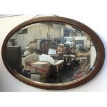 An oak framed oval wall mirror, with bevelled plate, 81x52, together with one other mid-century