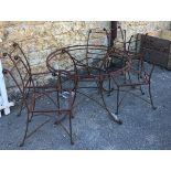 A wrought iron garden table, with six matching chairs (no top or seats)