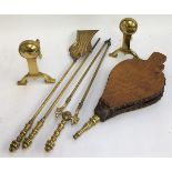 A pair of brass fire dogs; together with a set of brass fire tools (shovel, poker, tongs); and a set