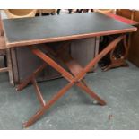 A folding campaign table with leather top 58x91cmW; together with a folding glazed embroidered