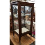 A small mahogany Regency glass display cabinet, with barbers pole banding, two modern glass shelves,