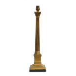 A gilt metal table lamp in the form of a fluted corinthian column, on square base upon an ebonised