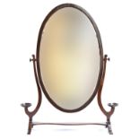 A 19th century oval adjustable dressing mirror, with turned candle sconces