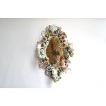 A Sitzendorf wall mirror, with encrusted floral decoration alongside a cherub, with three