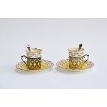 A pair of Aynsley coffee cans and saucers, the cans set within pierced silver holders with scroll