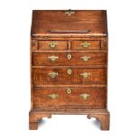 A small George III oak bureau, fall front over two short and three graduating drawers, on bracket