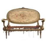 A late 19th century French giltwood open arm sofa, in need of much restoration, on tapering fluted