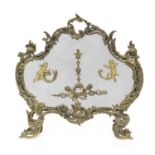 An ornate Louis XVI revival gilt metal fire screen, of scrolling foliate rococo influence, the