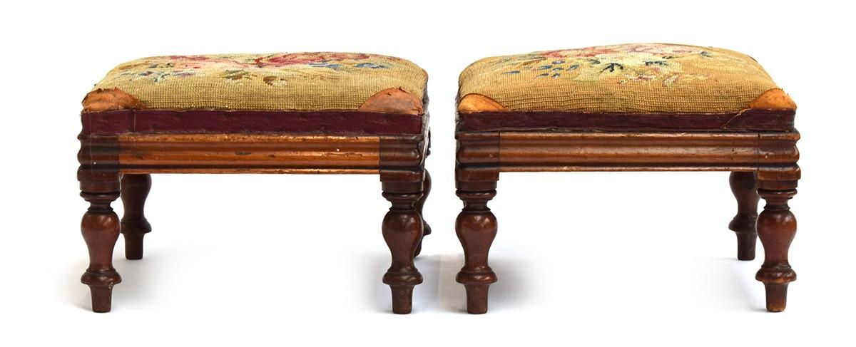 A pair of early 20th century embroidered footstools raised on turned legs, each 29cm square