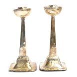 A pair of unusual silver candlesticks, Birmingham 1929, hemispherical bobeches on square taped