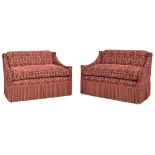 A pair of modern upholstered banquettes with fringe, on faux bamboo turned tapered legs, with