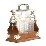 A two decanter silver plated oak tantalus, by Martin Hall & Co., Sheffield, square cut glass