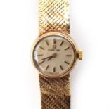 An Omega 9ct gold ladies cocktail watch, integral mesh bracelet, the silvered dial with baton