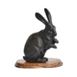 A Japanese bronze figure of a hare, with impressed seal mark to base (Norimitsu?), on hardwood