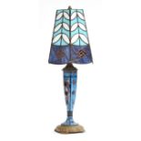 An Art Deco Tiffany style table lamp and shade, the brass base with hand painted enamel stem