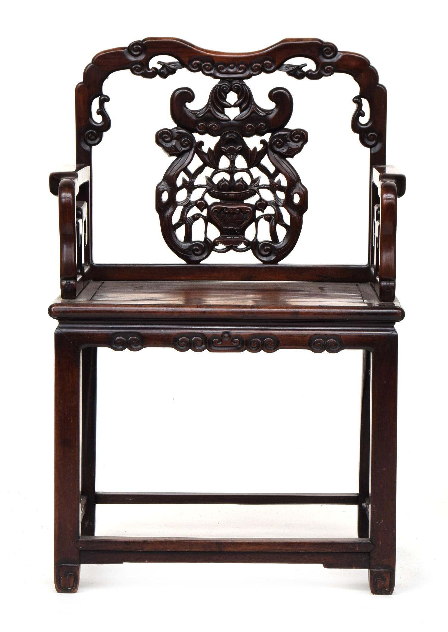 A Chinese hardwood elbow chair, the shaped back with pierced and carved peach and scroll ornament,