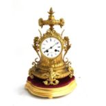 A French brass mantel clock, having ram's head and scrolling acanthus decoration, the dial with