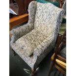 A 20th century upholstered wingback armchair