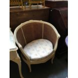 A wide double caned and white painted bergere chair, needs restoration