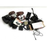 A mixed box of vintage cameras in carry cases, to include Voightlander, various military binoculars,