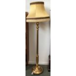 A gilt standard lamp with shade