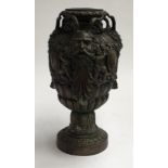 A cast metal vase decorated with Pan masks, 30cmH