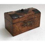 An early 20th century walnut tea caddy, domed top with single stone and pierced metal decorations,