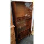 A mid-century bookshelf with glazed sliding doors over cupboard