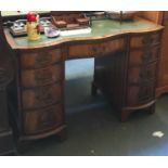 A kneehole desk, leather inset top, with traditional arrangement of drawers, 115cmW