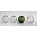 Four fisherman's floats, three clear, one green glass