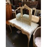 A white painted dressing table, with three part adjustable dressing mirror, shaped glass top over