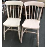 A pair of white painted stickback kitchen chairs