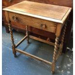 A small oak side table, molded top over single frieze drawer on barley twist legs with peripheral