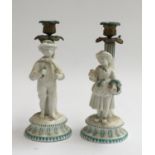 A pair of white and green glazed figural ceramic candlesticks