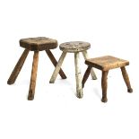 Two three legged milking stools, 33cmH and 29cmH; together with one other (3)