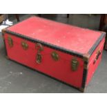 A red canvas covered travel trunk