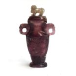 A Chinese carved quartz vase with cover and tao tieh handles, the cover surmounted by a foo dog,