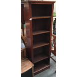 A narrow mahogany bookshelf on plinth base, 56x26x167cmH